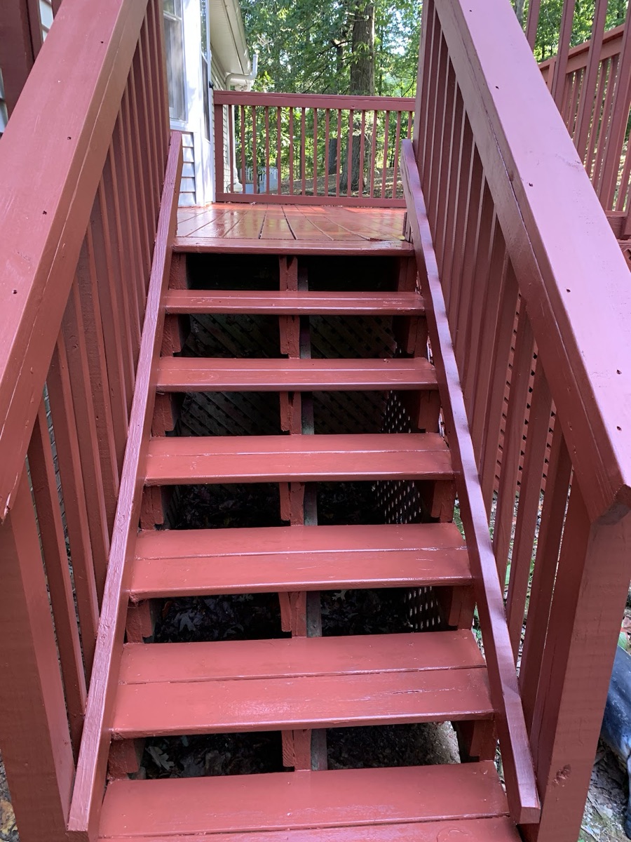 Freshly repaired and stained wooden deck stairs and railing
