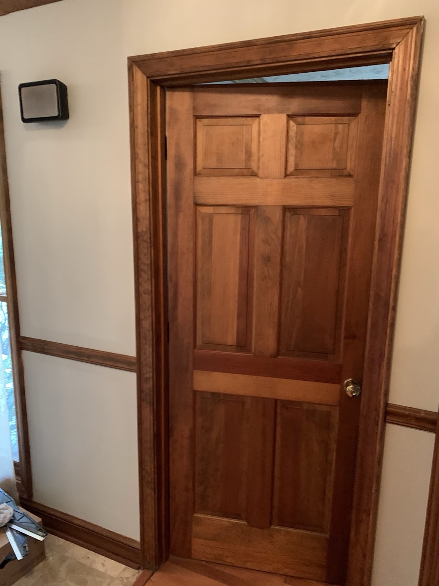A solid wood interior door and trim hung and finished