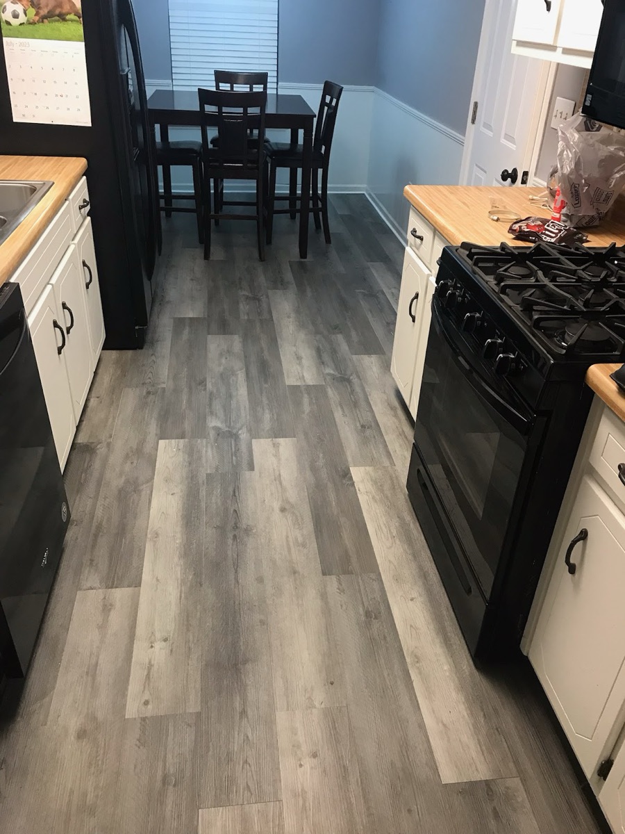 Newly installed gray vinyl plank flooring in a finished kitchen